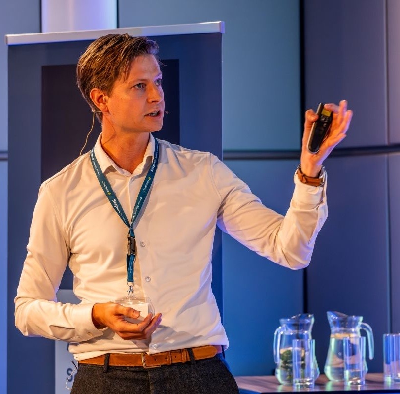 Laurentz Tonniau geeft een presentatie op een podium